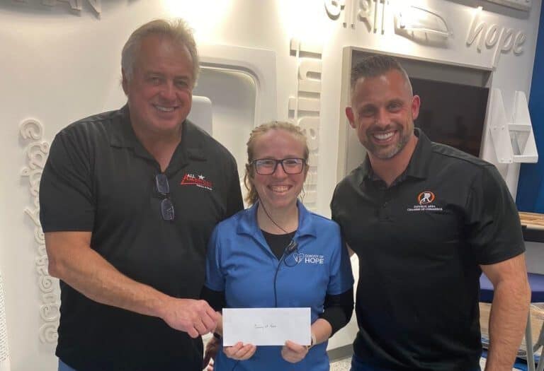 All American Rental Owner (and MRDA President) Scott Mitchell (L) and COO Macy Mitchell (R) present a check to Convoy of Hope Volunteer Coordinator Bethany Burrows in Springfield, Missouri.