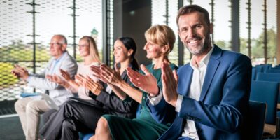 Happy audience applauding speaker at business conference