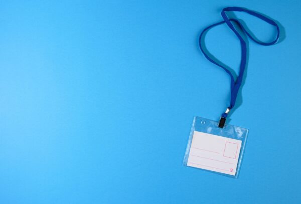 Transparent plastic badge on a blue lanyard on a blue background